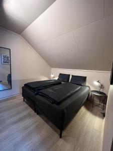 RjukanRjukan Sentrum Apartments NO 1的一间卧室,卧室内配有一张黑色大床