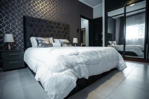 阿鲁沙African Oak: Rosewood的卧室配有一张白色大床和镜子