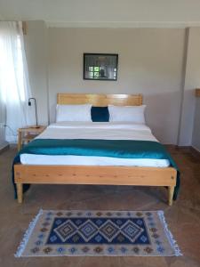 EmaliKIJIJI VILLAGE的一间卧室配有一张大床和木制床头板