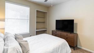 理查森Landing Modern Apartment with Amazing Amenities (ID6588X72)的一间卧室配有一张床和一台平面电视