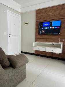 维拉维尔哈Ocean flat com vista pro mar 404的客厅配有沙发和墙上的电视