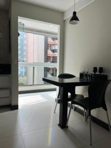 维拉维尔哈Ocean flat com vista pro mar 404的一间带桌椅和窗户的用餐室