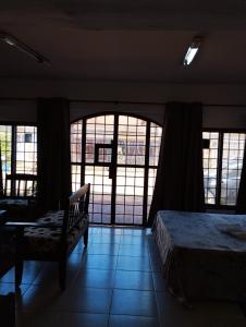 LuqueMangoty Apartamento的一间卧室配有一张床、一把椅子和窗户。