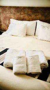 门多萨La Sofia Apart & Wines的床上有三条白色毛巾