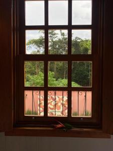 皮雷诺波利斯Pousada Mãe Natureza的开放式窗户,享有花园的景色