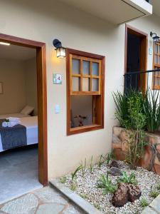 皮雷诺波利斯Pousada Mãe Natureza的一间设有一张床的房间和一扇带窗户的门