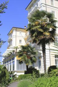蒙特勒雷上尉高尔夫酒店的一座白色的大建筑,前面有棕榈树