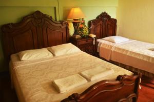 莱昂利昂酒店的一间卧室配有两张床和一张带台灯的桌子