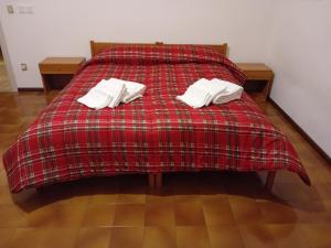 CampodennoCasa vacanze Monica的一张红色的床,上面有两个白色枕头