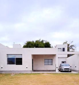 卡塔马卡Casa Valle Viejo的停在白色房子前面的汽车