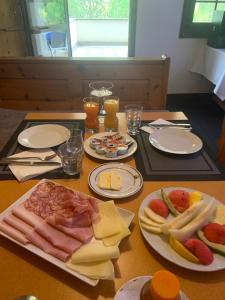 贝尔金Bed and Breakfast Darlux的餐桌,盘子上放着肉、奶酪和饮料