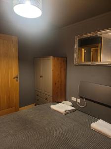布罗德福德THE MOORINGS的一间卧室配有一张带镜子和水槽的床