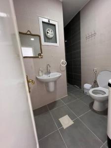卡拉克The guset house的一间带水槽、卫生间和镜子的浴室