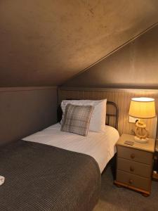 布罗德福德THE MOORINGS的一间卧室,配有一张床和床头灯