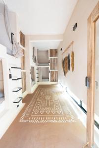 埃斯孔迪多港Secret Beach Hostel的一间走廊的房间,地板上铺有地毯