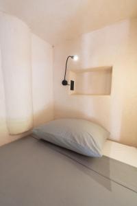 埃斯孔迪多港Secret Beach Hostel的一张位于带灯的小房间的床