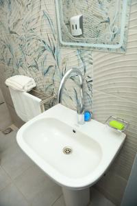 阿斯旺Crystala guest house的浴室设有白色水槽,装饰有蓝色和白色的壁纸