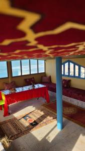 西迪伊夫尼Suerte Loca的一间设有桌子和红色天篷的房间