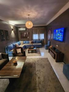 马拉喀什Aprt 4 Family的客厅配有蓝色的沙发和电视