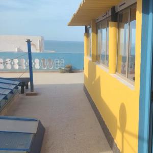西迪伊夫尼Suerte Loca的黄色和蓝色的建筑,享有海景