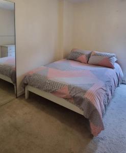 ColindaleTwo bed Apartment free parking near Colindale Station的一间卧室配有一张床和镜子