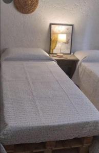 帕尔克德尔普拉塔El Bosque +598 94625953的一间卧室配有两张床和一张带台灯的桌子