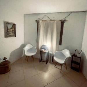 帕尔克德尔普拉塔El Bosque +598 94625953的一间设有两把白色椅子和窗户的房间