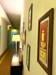 拉弗洛雷斯塔Hotel Vista La Floresta的墙上挂有画作的走廊和一盏灯