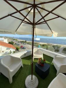 拉弗洛雷斯塔Hotel Vista La Floresta的庭院配有两把白色椅子和遮阳伞