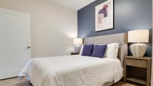 巴尔的摩Landing Modern Apartment with Amazing Amenities (ID7709X66)的一间卧室配有一张蓝色墙壁的床和两盏灯。