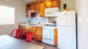 摩押Downtown Cozy Home Base - Purple Sage 7的厨房配有白色冰箱、桌子和椅子