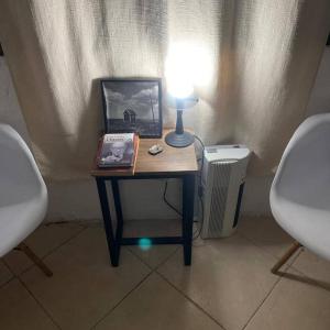 帕尔克德尔普拉塔El Bosque +598 94625953的一张桌子,上面有台灯和一张照片