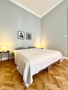 布达佩斯Gellert Danube Panorama Apartment的白色卧室设有一张大床和木地板