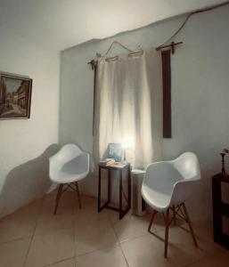 帕尔克德尔普拉塔El Bosque +598 94625953的两把白色椅子坐在带桌子的房间