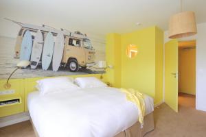 曼德琉-拉纳普勒Hotel Casarose - Cannes Mandelieu的一间卧室配有一张床,墙上装有冲浪板的货车