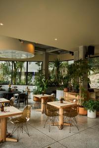 麦德林The Somos Flats Central Poblado的一间设有桌椅的餐厅,种植了植物