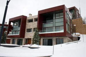 Abū MīzānLES Dunes De Faqra ( c duplex )的前面有雪的红色建筑
