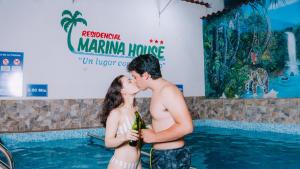 塔拉波托Residencial Marina House的两个在游泳池前亲吻