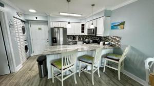 皮尔斯堡Ocean Village的厨房配有带椅子和台面的岛屿