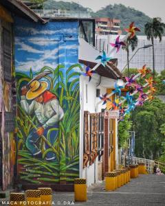 卡利HOSTAL CHONTADURO Casa colonial en pleno centro histórico de Cali- Se alquila la casa entera para 12 o 13 personas o por habitaciones的一座建筑的侧面壁画,放风筝