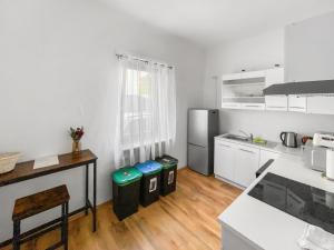 萨尔布吕肯CityChalet Monteur Apartments的厨房铺有木地板,配有白色橱柜。