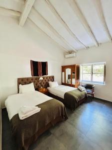 Colonia Las Rosas泊戴斯巴耶 - 合众精品酒店的酒店客房设有两张床和窗户。
