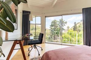 洛杉矶Stunning Hollywood Midcentury Modern-Views-Best Location!的一间卧室设有一张桌子和一个大窗户