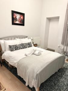 爱丁堡C&E Apartment的一间卧室配有带白色床单和枕头的床。