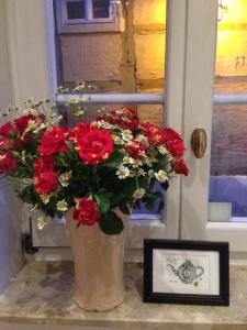 奎德林堡杜斯查兹酒店的花瓶,满是红花,紧靠窗户