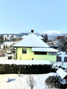 利波瓦Domek u podnóża Skrzycznego的上面有雪的黄色房子
