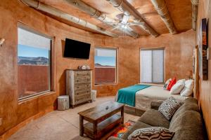 维尔京Zion White Bison Glamping & RV Resort的一间卧室配有一张床、一张沙发和一台电视。