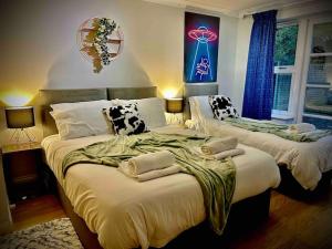 科尔切斯特5 Bedroom House-Sleeps 13-Big Savings On Long Stays!的一间卧室配有两张带毛巾的床