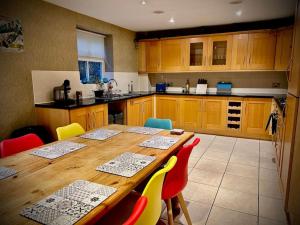 科尔切斯特5 Bedroom House-Sleeps 13-Big Savings On Long Stays!的厨房配有木桌和五颜六色的椅子