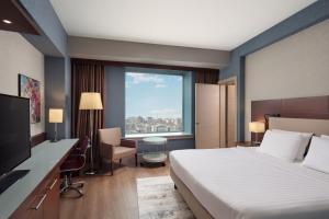 伊斯坦布尔Delta Hotels Istanbul West的配有一张床、一张书桌和一扇窗户的酒店客房